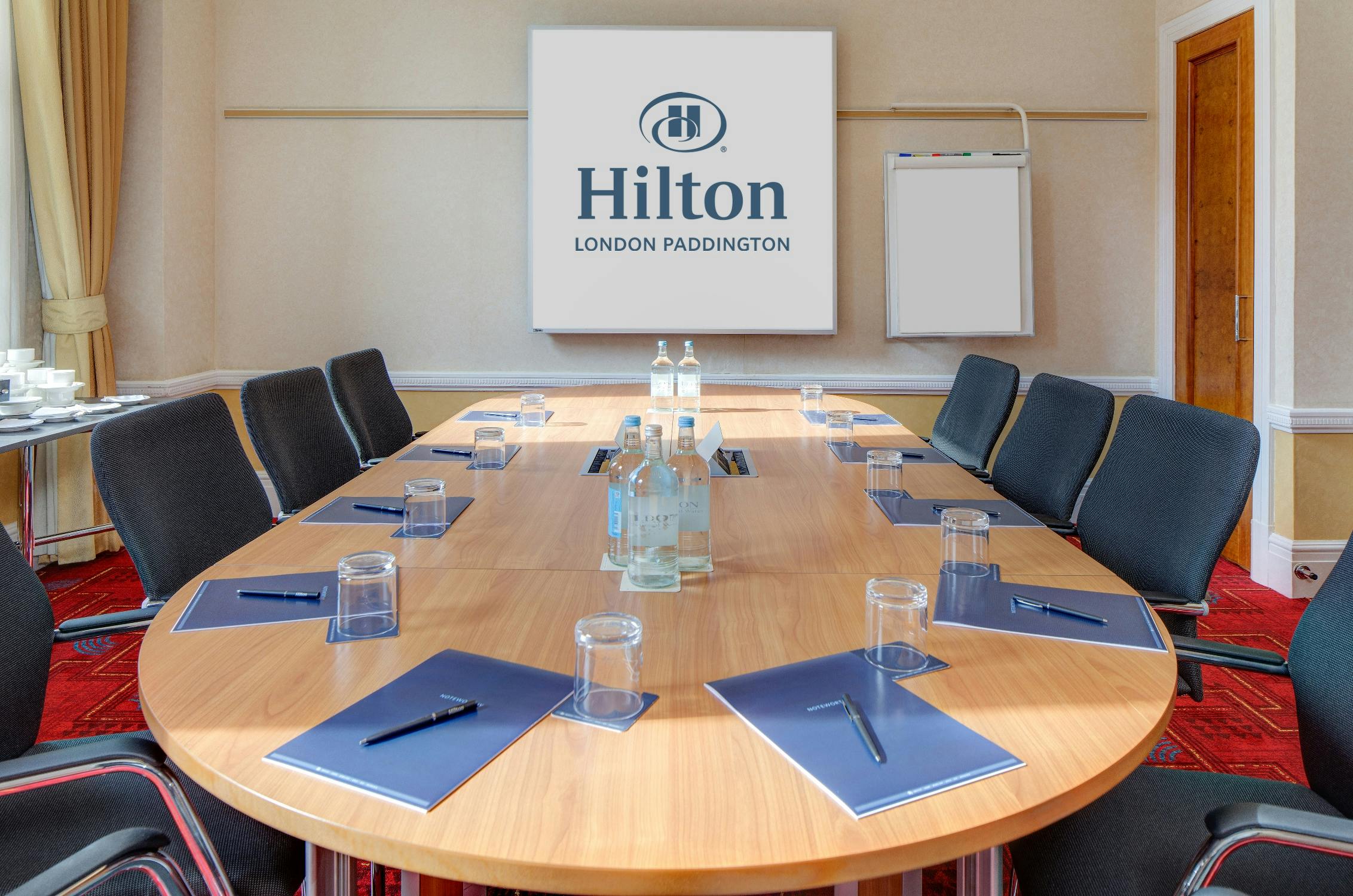 Meeting room at Hilton London Paddington with oval table, ideal for corporate events.