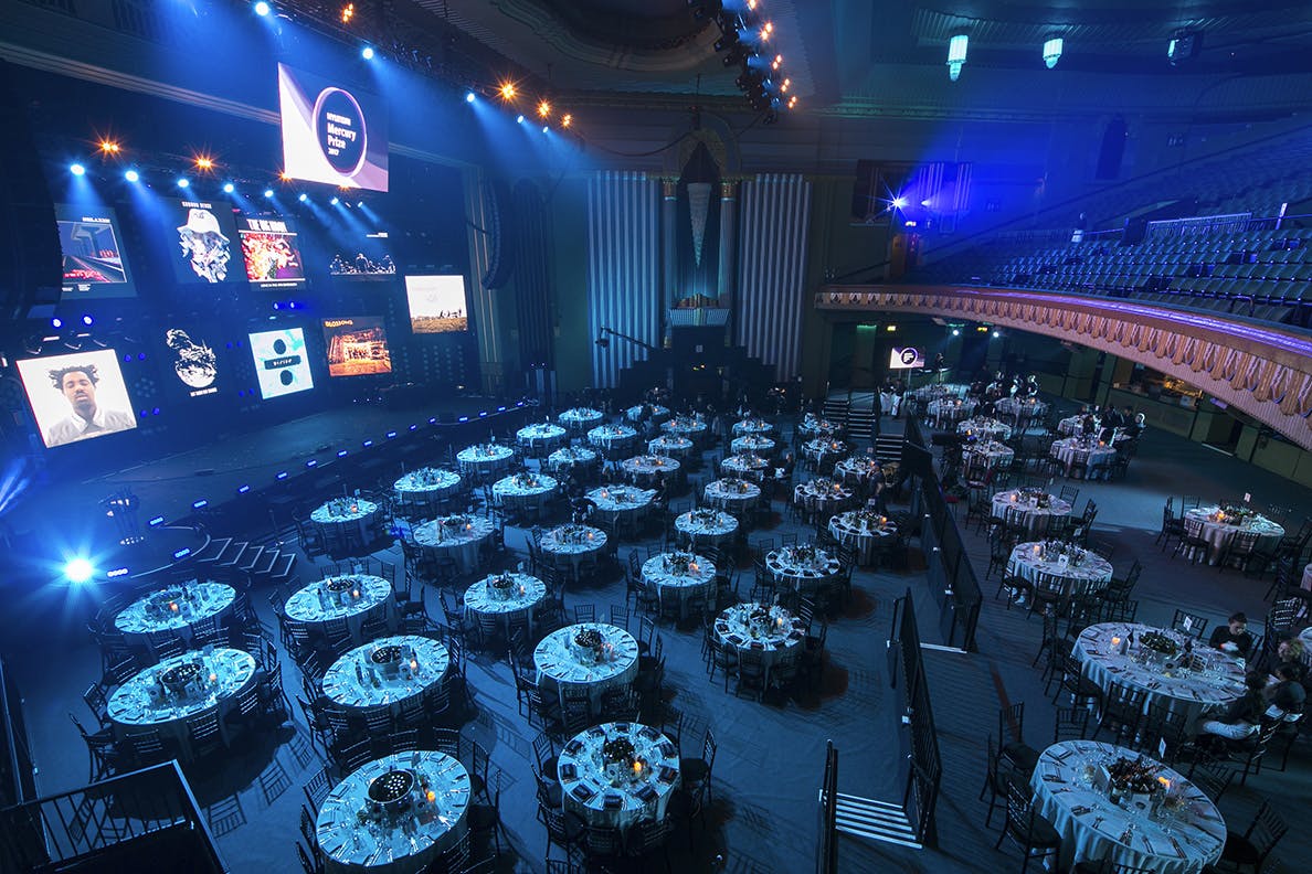 Whole Venue Eventim Apollo with elegant round tables for networking and celebration.