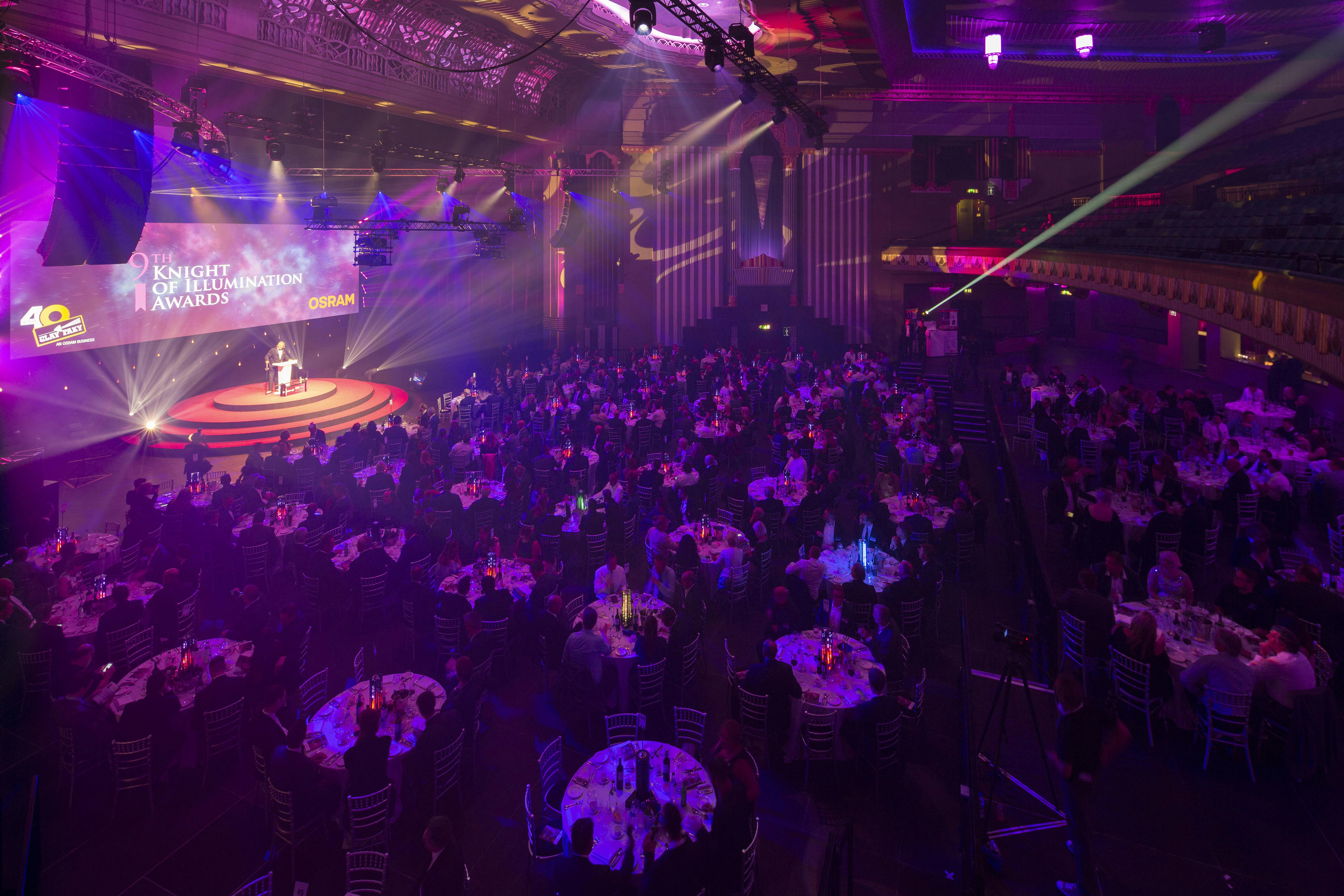 Vibrant gala event at Eventim Apollo with elegant tables and dynamic stage lighting.