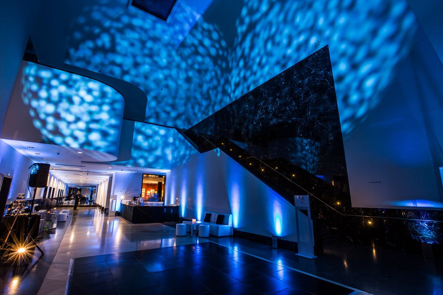 Annenberg Court at The National Gallery, modern event space with dramatic blue lighting.