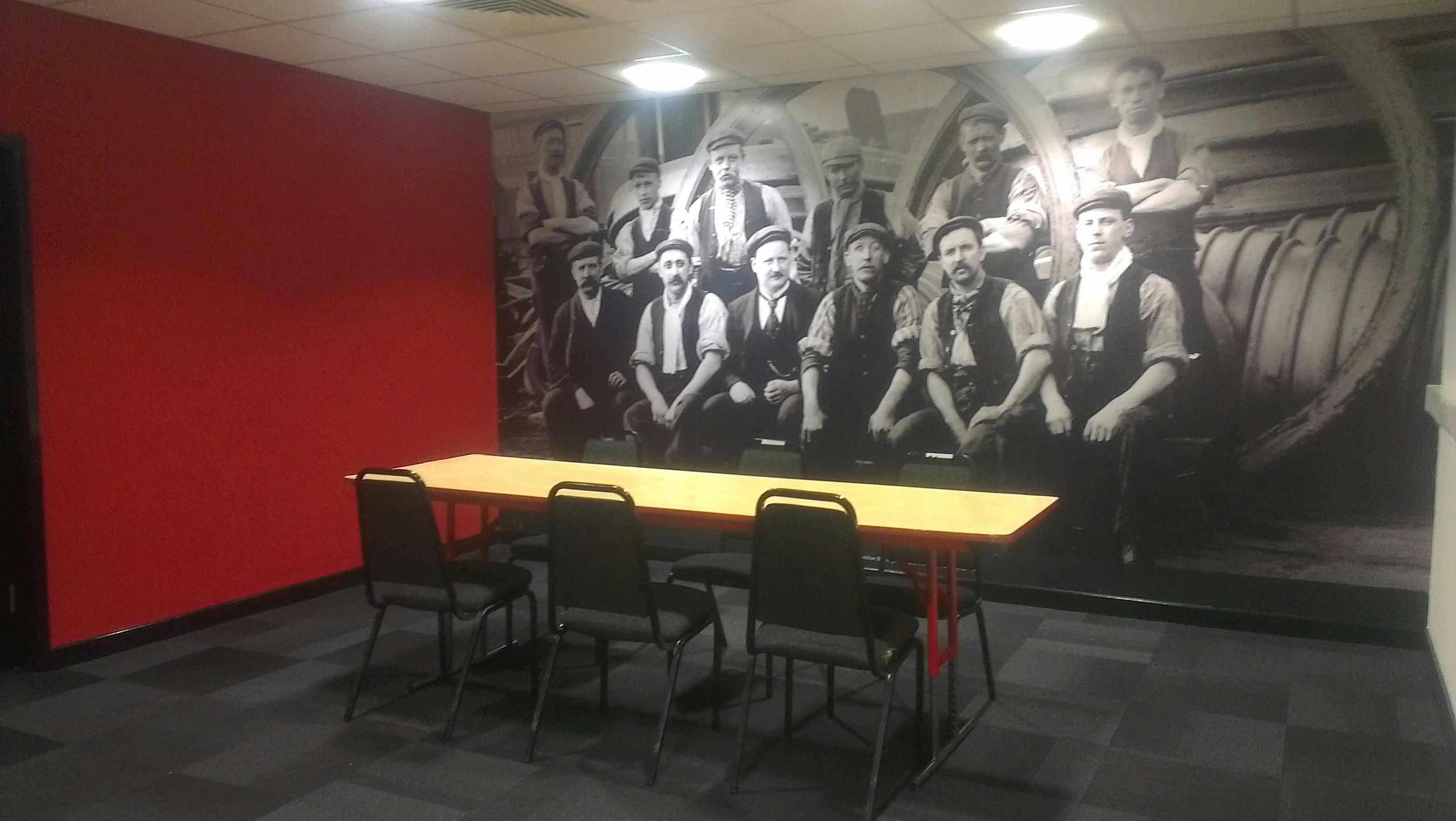 Conference room with historical mural, ideal for meetings and brainstorming sessions.