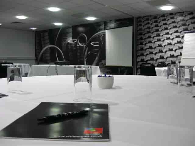 Modern conference room with white table setup, perfect for meetings and presentations.