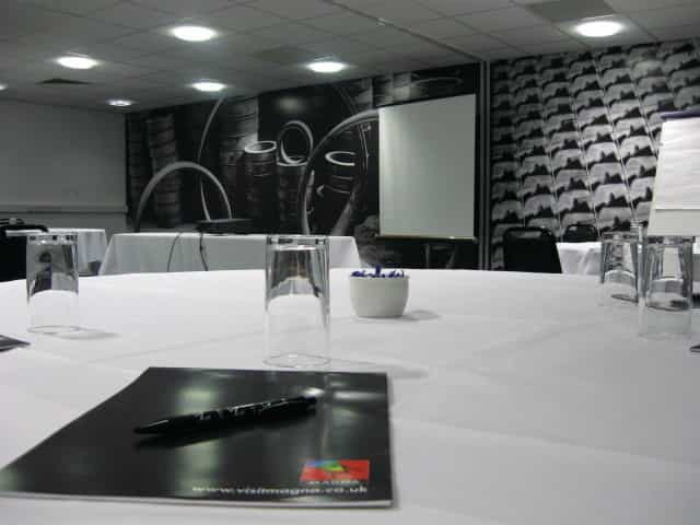 Modern conference room with white table setup, perfect for meetings and presentations.