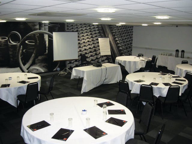 Modern conference room with round tables, ideal for meetings and presentations.