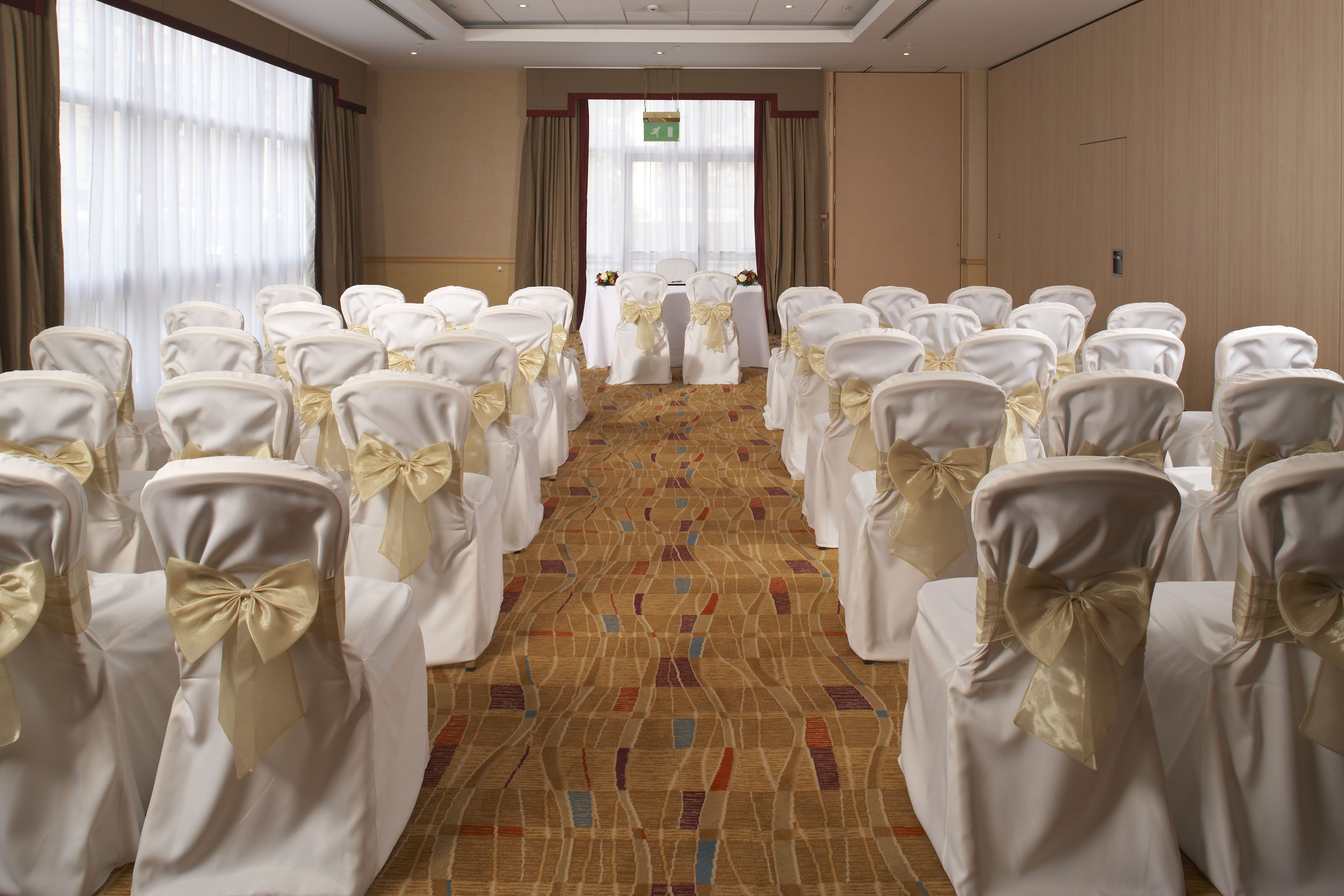 Hilton Bath City County Suite wedding ceremony with theater seating and elegant chair covers.