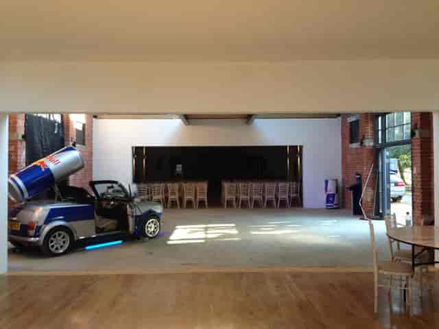 The Bomb Factory event space with vintage car and Red Bull can, ideal for creative gatherings.