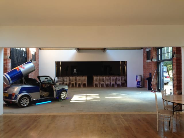 The Bomb Factory event space with vintage car and Red Bull can, ideal for creative gatherings.