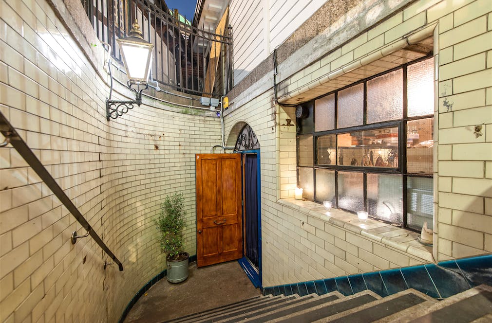 Charming wine bar with vintage staircase, perfect for intimate events and workshops.