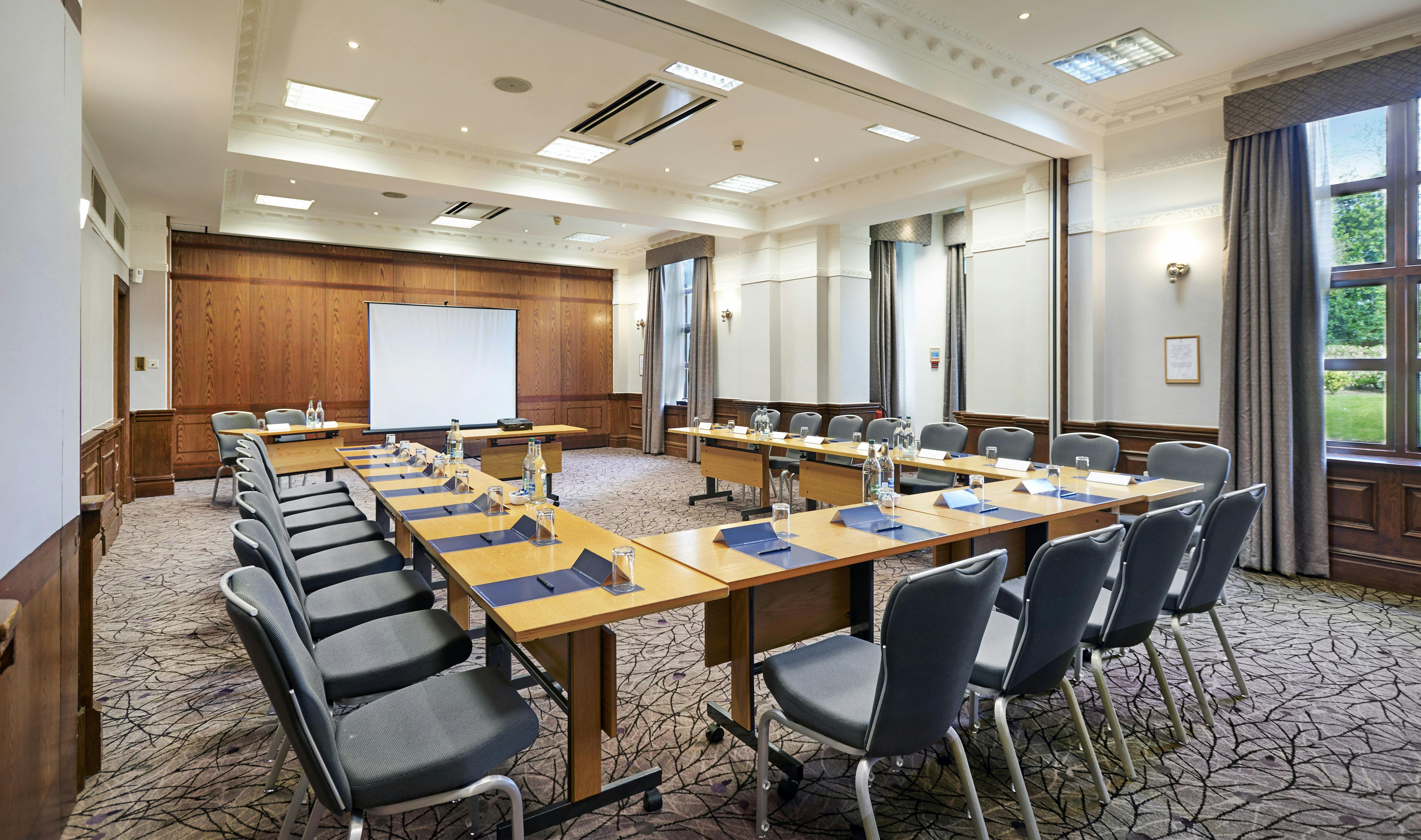 Limes Suite meeting room at Hilton Puckrup Hall, Tewkesbury, with natural light and projector.