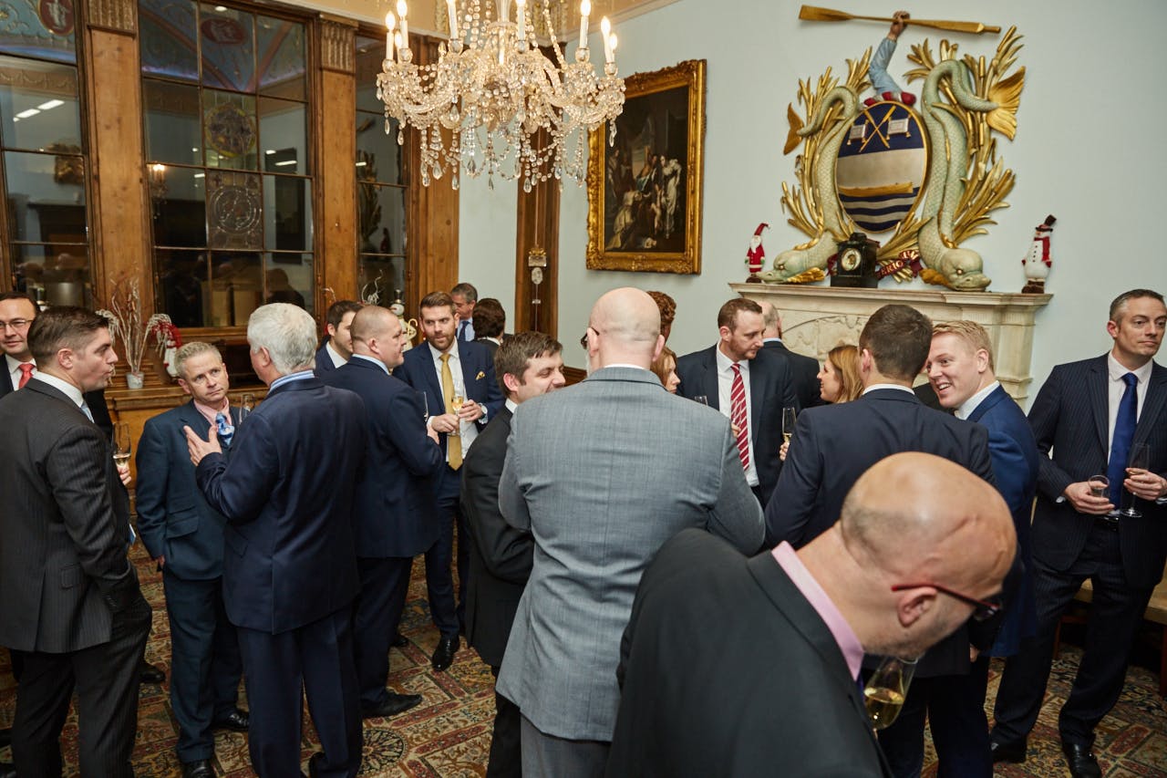 Elegant networking event at Watermen's Hall with professionals in formal attire.