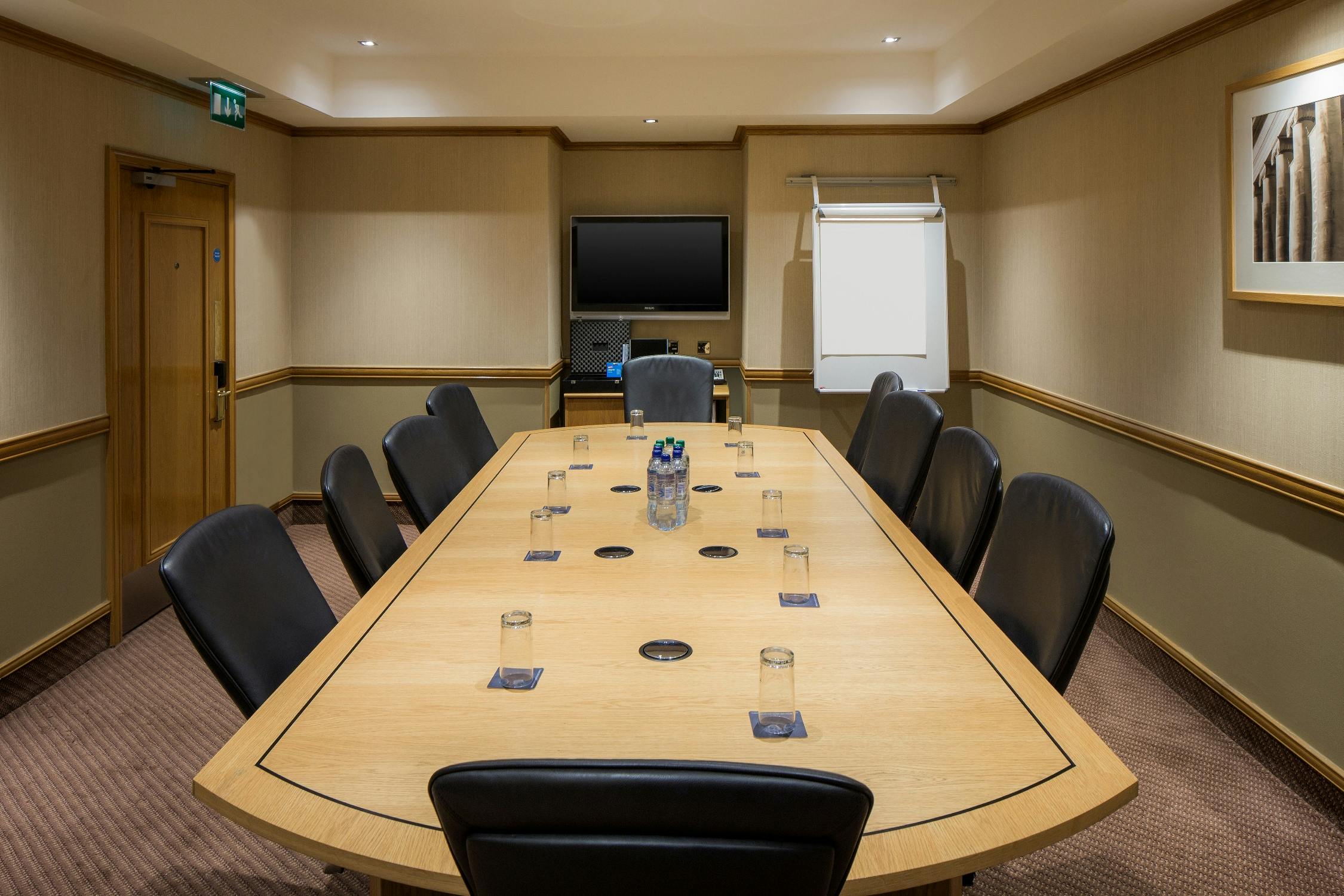 Boardroom at Edinburgh Grosvenor Hotel with wooden table, ideal for meetings and presentations.