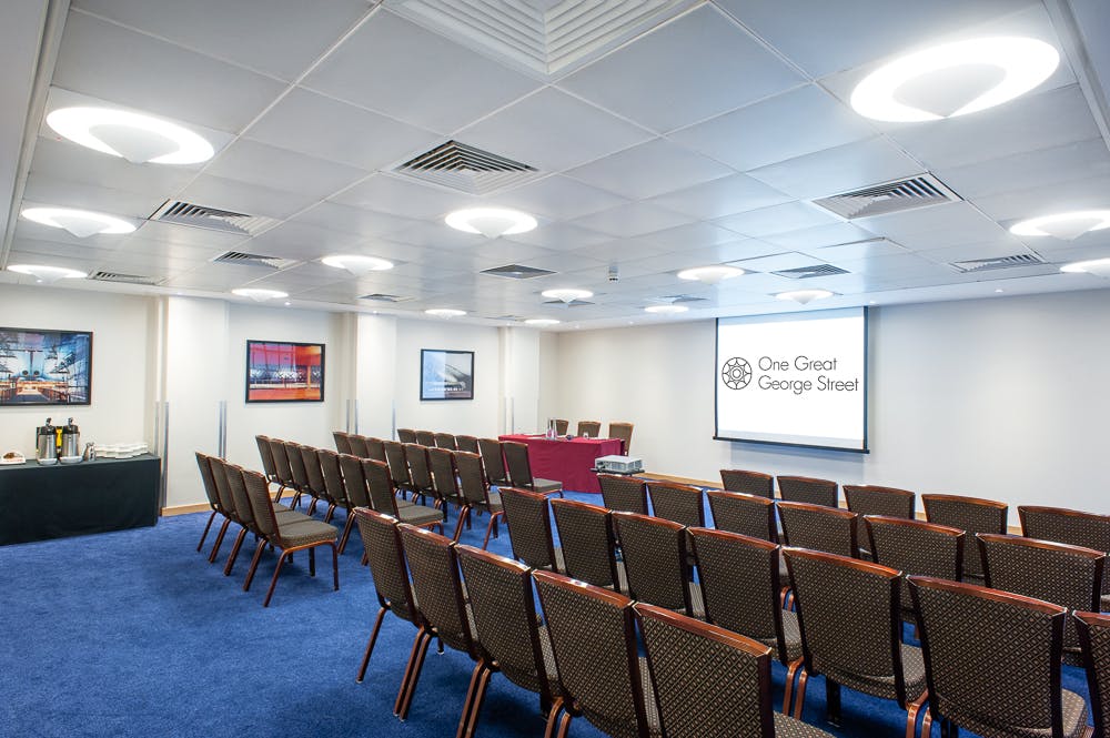 Palmer Room conference setup with chairs and screen for corporate events or workshops.