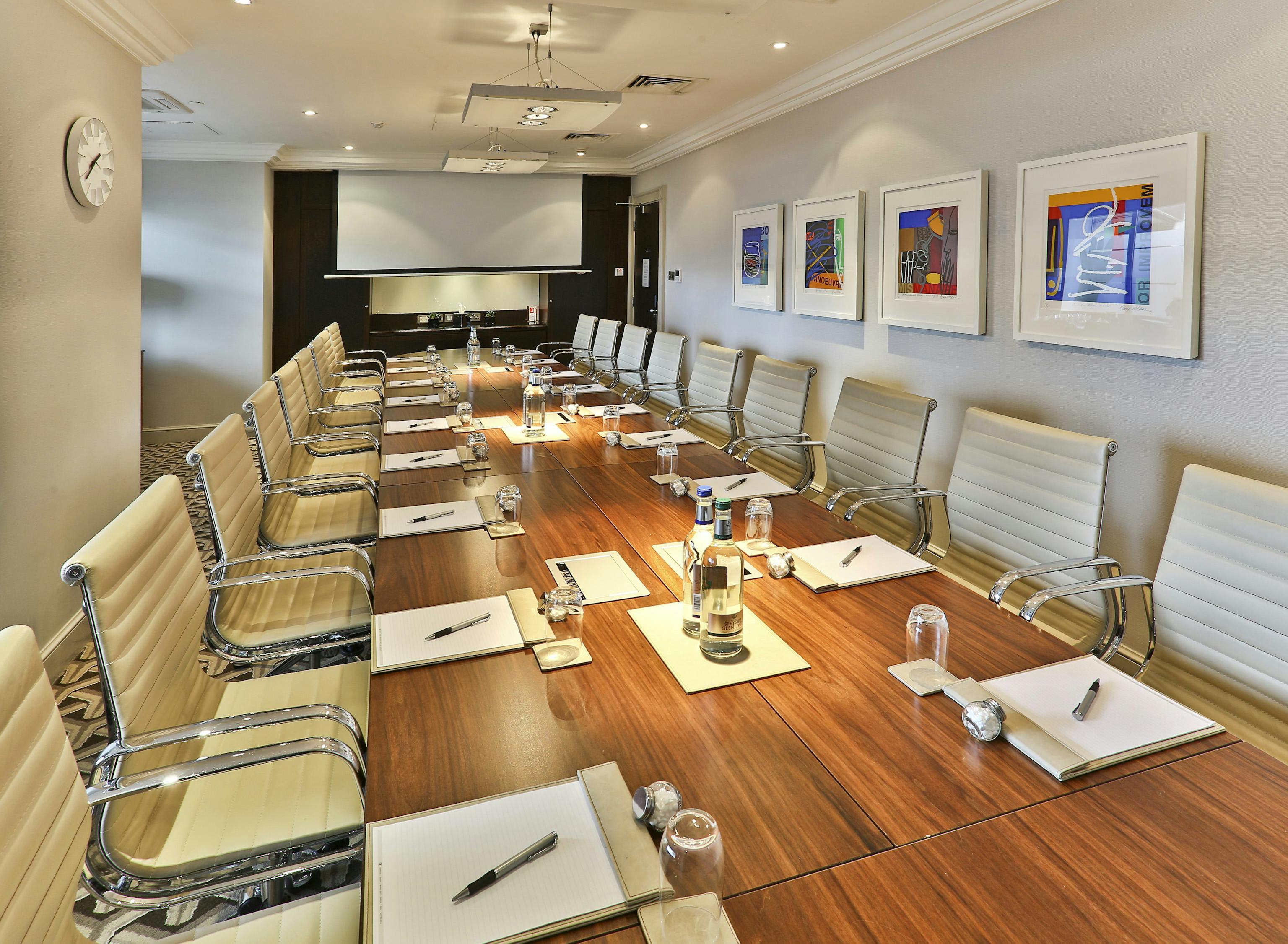 Marlborough Suite conference room at London Hilton, featuring a long table and projector screen.