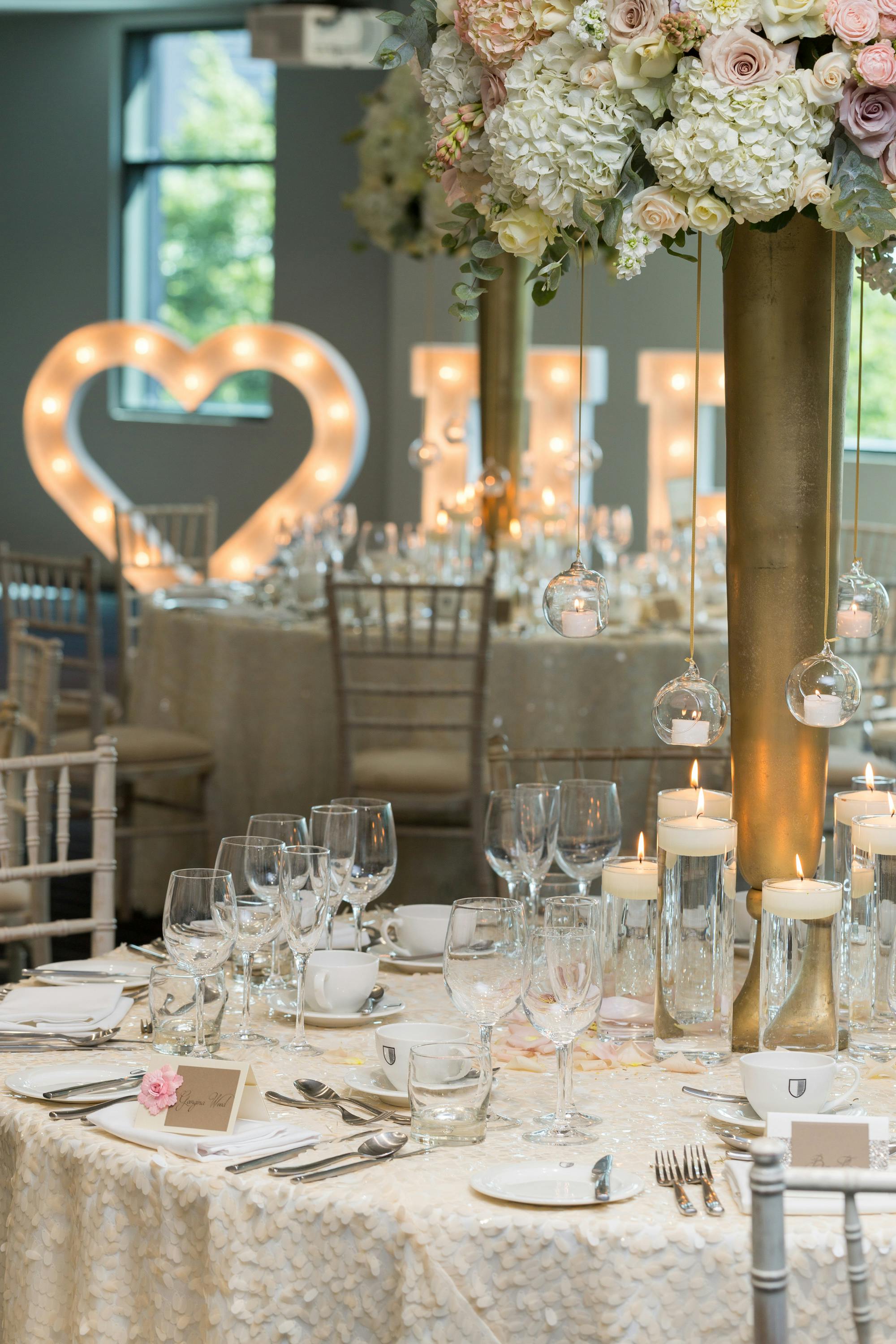 Elegant wedding event space with romantic decor and heart-shaped illuminated letters.