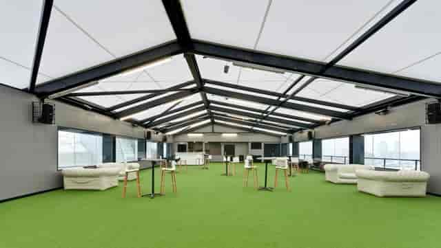 Modern event venue Heaven in Hotel Football with white seating and green flooring.