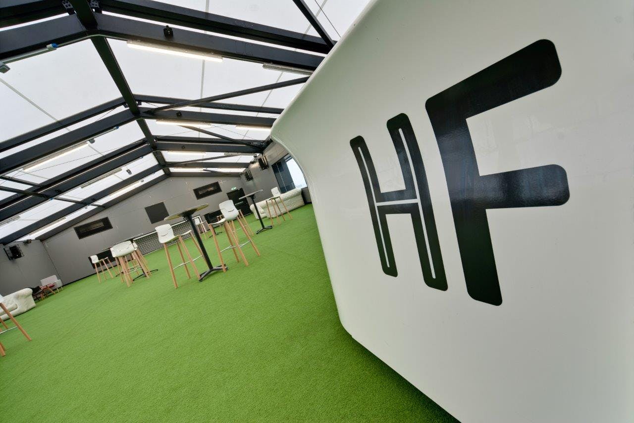 Modern event space with turf flooring at Hotel Football for networking and gatherings.