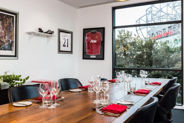 Stylish meeting room at Hotel Football with wooden table, ideal for corporate events.