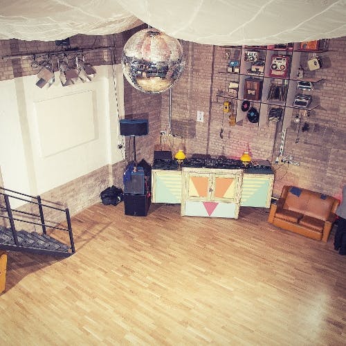 Versatile event space with wooden floor, disco ball for parties and gatherings.