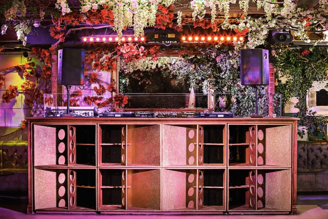 Vibrant Cuckoo Club event space with floral DJ booth, perfect for parties and celebrations.