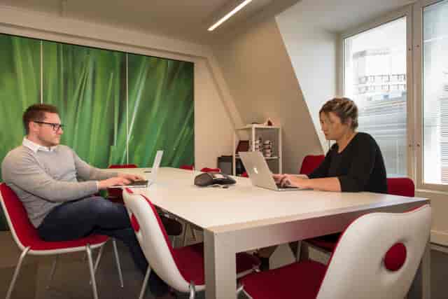 Modern video conferencing room with green backdrop, ideal for team meetings and collaboration.