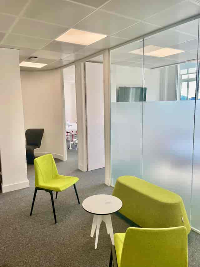 Modern meeting room for 8 with green seating, perfect for brainstorming sessions.