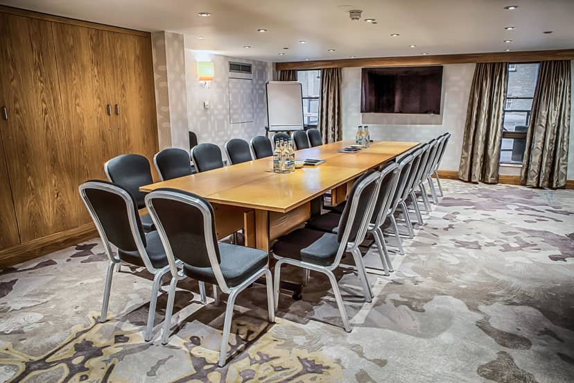 Holland Suite meeting room at Hilton London Kensington, featuring a long wooden table.