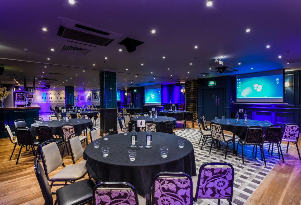 Minster Suite event space with round tables, ideal for meetings and gatherings.