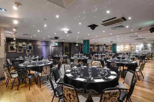 Elegant Minster Suite event space with round tables, perfect for corporate gatherings.