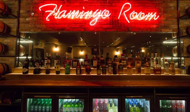 Vibrant bar at O'Neill's Wardour Street with neon sign, perfect for networking events.