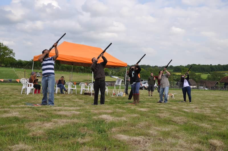 Outdoor team-building event at a glamping venue with shaded seating and tents.
