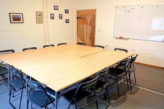 Versatile meeting room with large table, ideal for workshops and collaborative discussions.