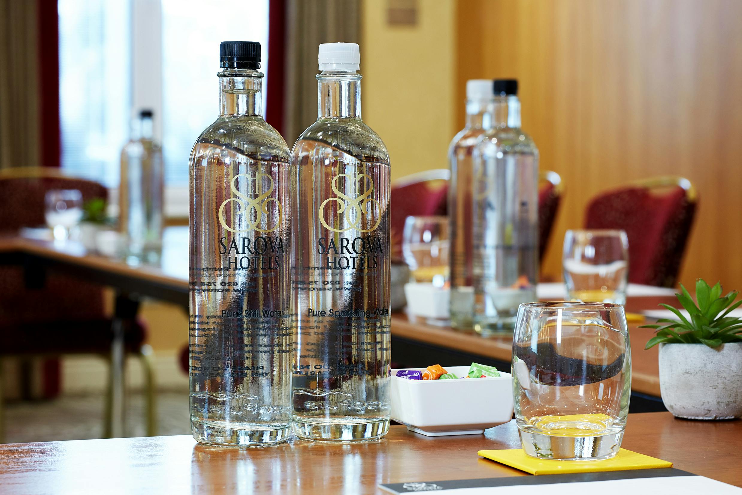 Elegant meeting setup in Charles Suite, The Rembrandt, with bottled water and glassware.