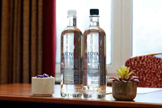 "Elizabeth suite meeting setup with water bottles, succulent, and colorful cup for events."