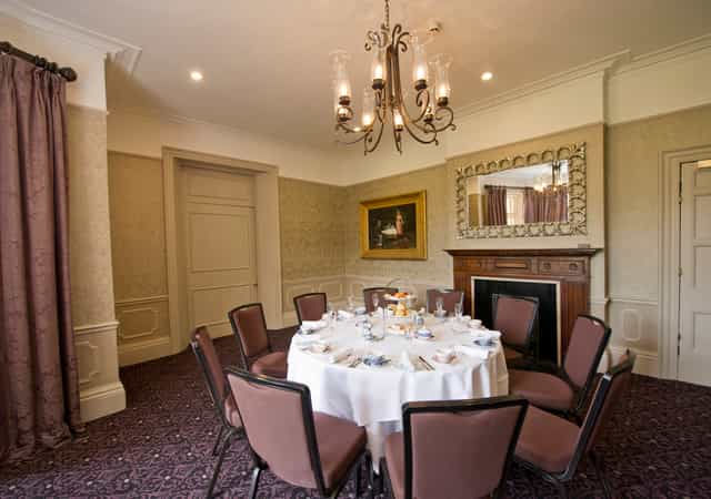 Elegant meeting space with round table for upscale events at Woodlands Park Hotel.