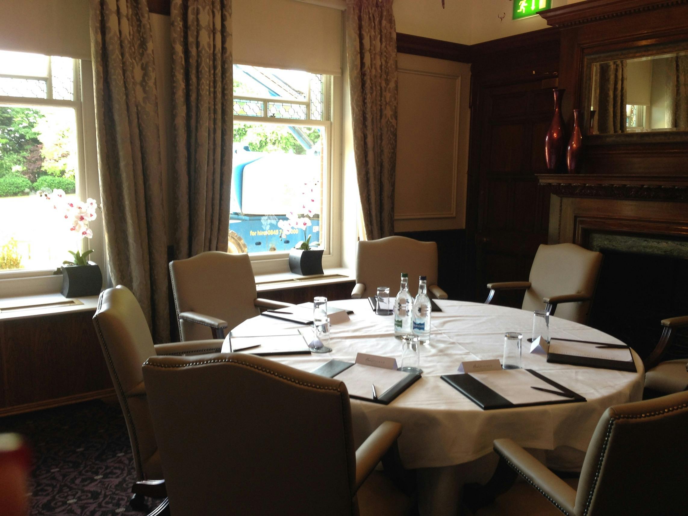 Boardroom at Woodlands Park Hotel with round table for meetings and natural light.