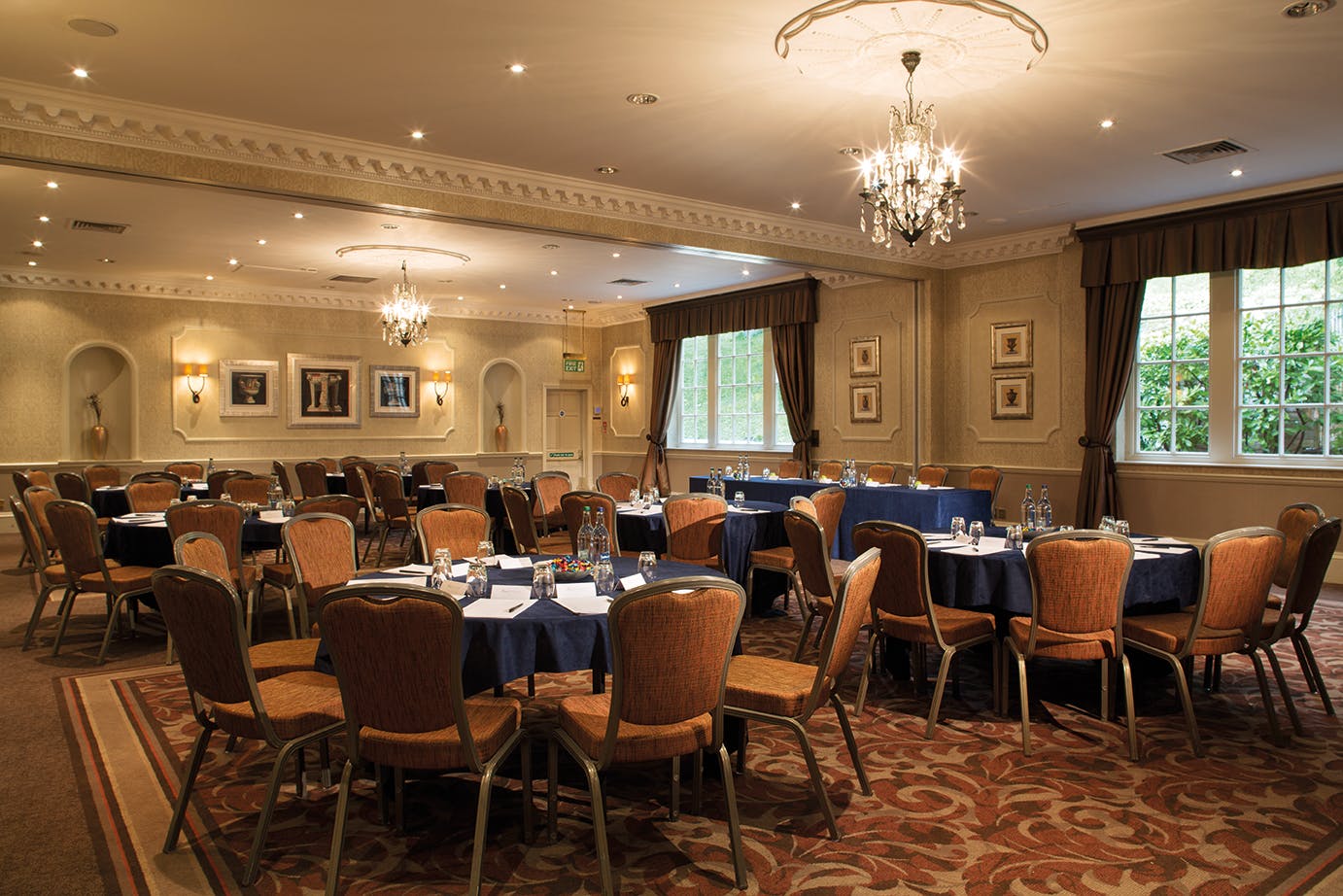 Vavasour Suite at Wood Hall Hotel, elegant meeting room with navy tables for corporate events.