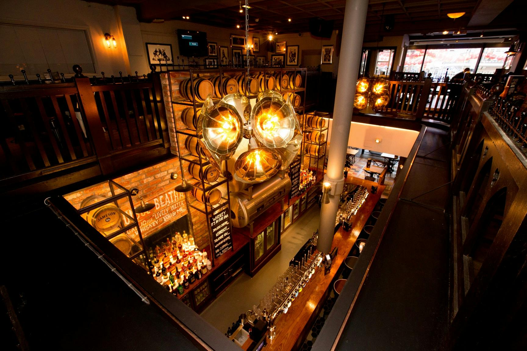 Stylish bar area with wooden barrels at O'Neill's Wardour Street for events and gatherings.