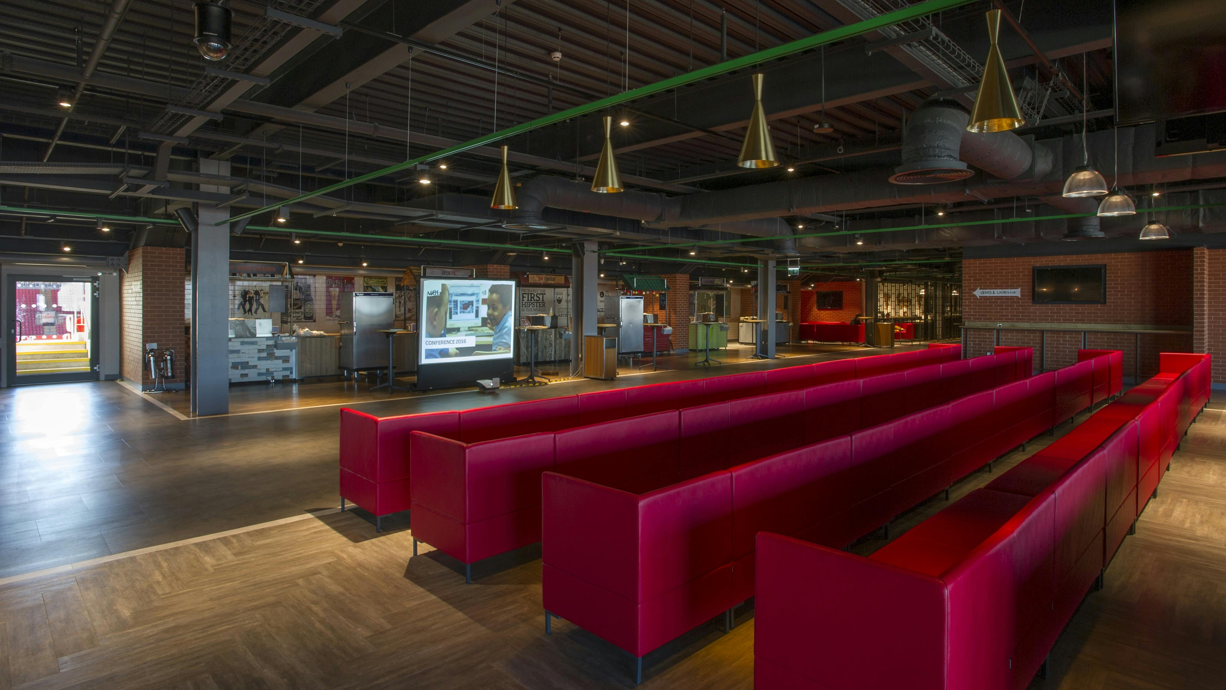 Carlsberg Dugout at Liverpool FC: modern event space with red seating for conferences and workshops.