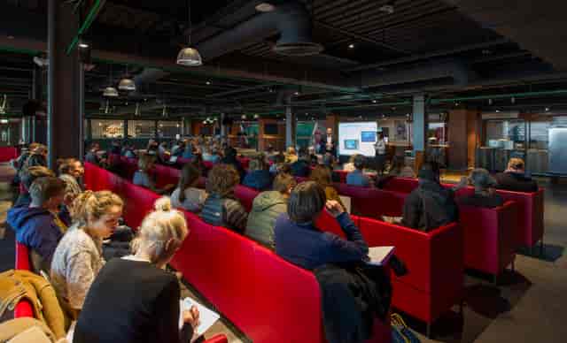 Carlsberg Dugout seminar with engaged audience in modern, comfortable seating.