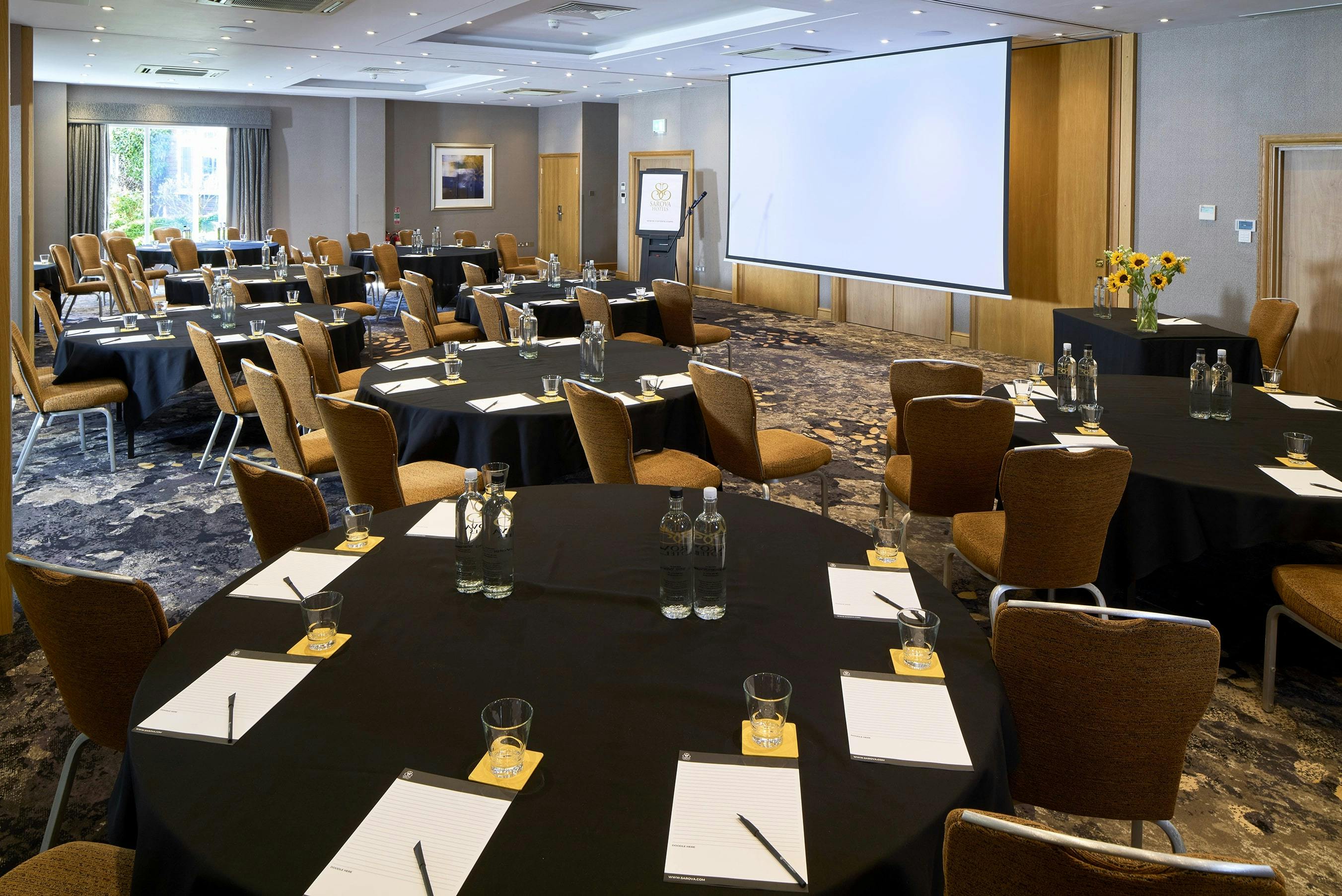 Thames Suite meeting room with round tables, ideal for professional events and networking.