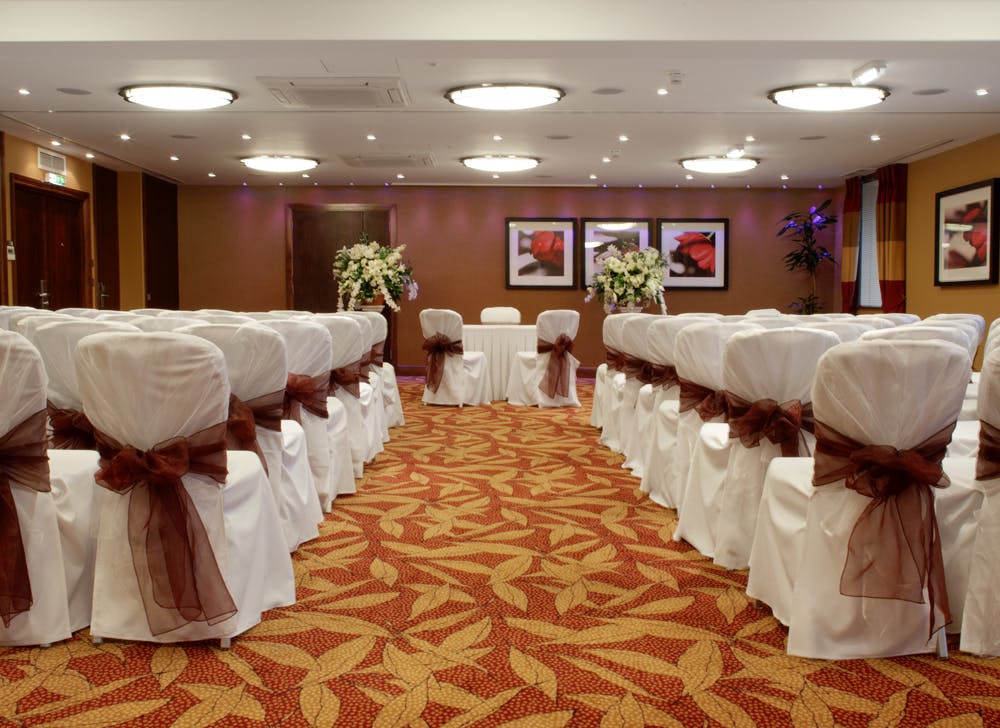 Chalfont Suite at The Bull Hotel, elegant meeting space with white chairs and brown sashes.