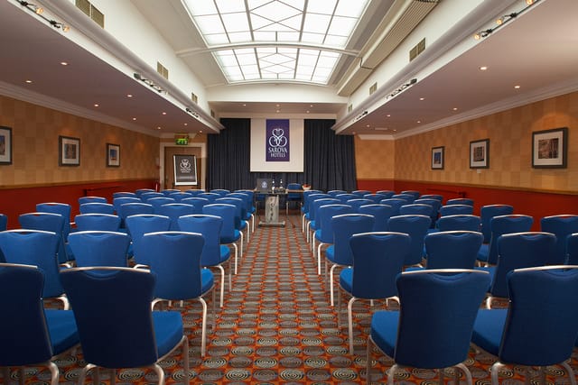 Shaw Suite meeting room with blue chairs, ideal for conferences and workshops.