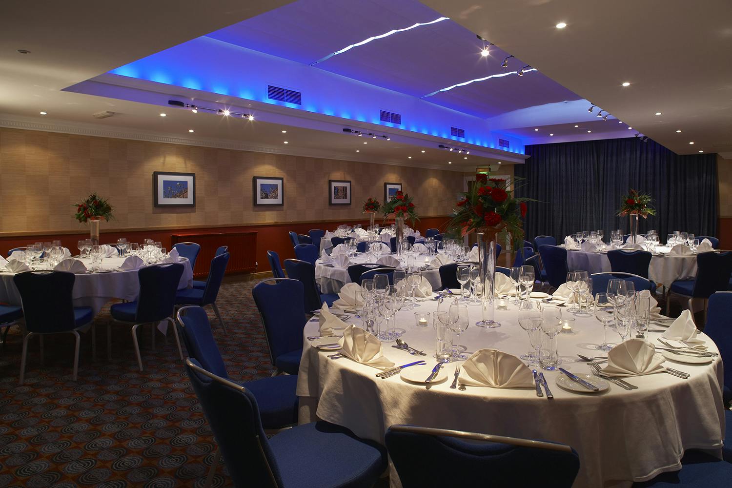 Elegant Shaw Suite banquet room with blue lighting, perfect for weddings and corporate events.