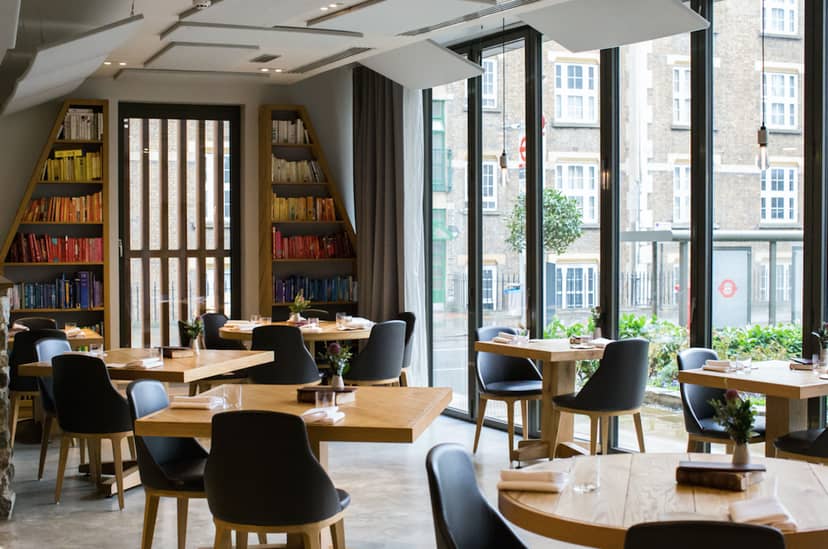 Modern restaurant with round tables, ideal for networking events and intimate gatherings.