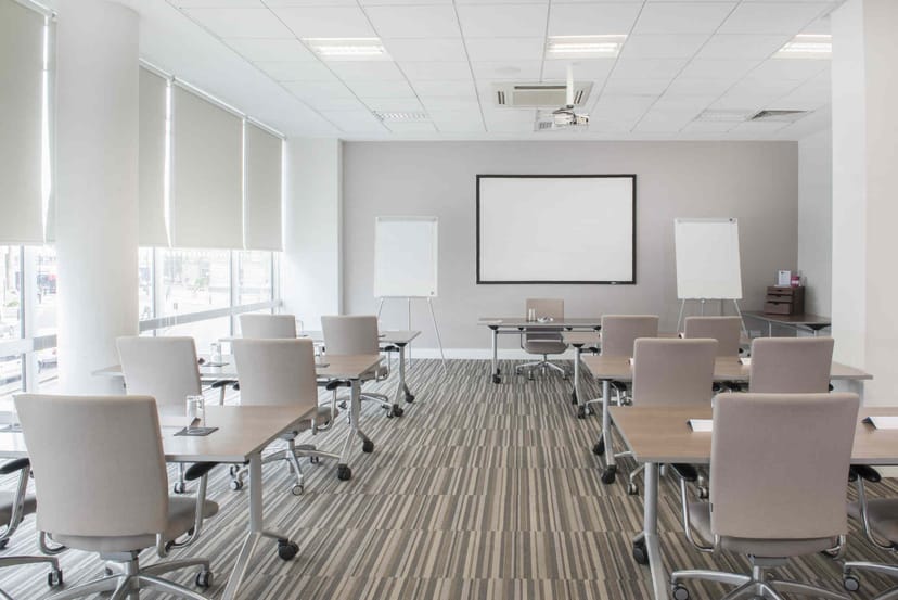 Classroom-style meeting room with neutral decor, ideal for corporate training and workshops.