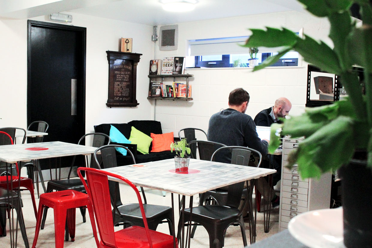 Cozy hot desk meeting space with vibrant cushions for brainstorming and networking events. - Banner