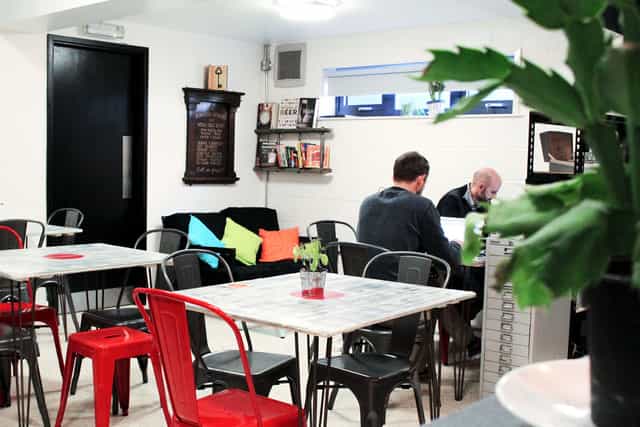 Cozy hot desk meeting space with vibrant cushions for brainstorming and networking events.