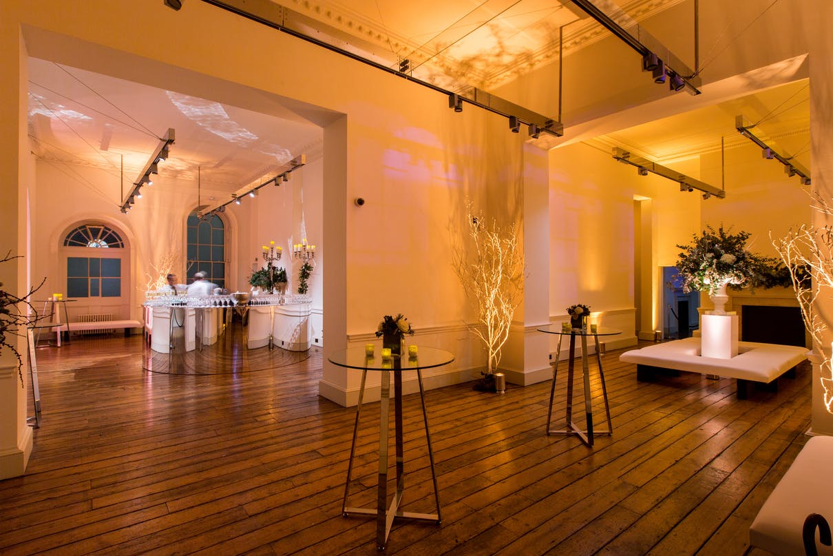 Elegant event space in Somerset House's East Wing with warm lighting and floral decor.