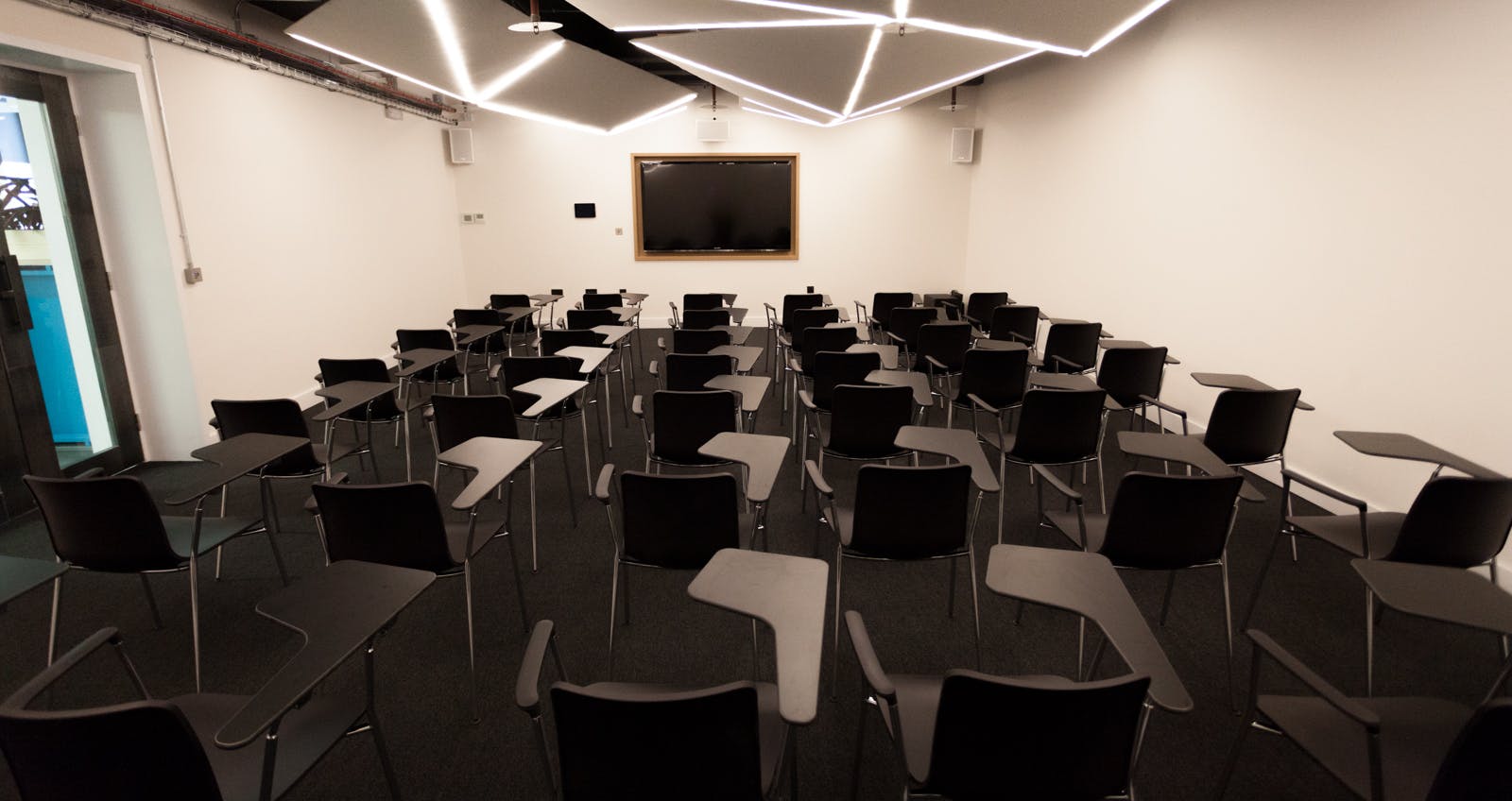 Modern meeting room with black chairs, ideal for presentations and workshops.