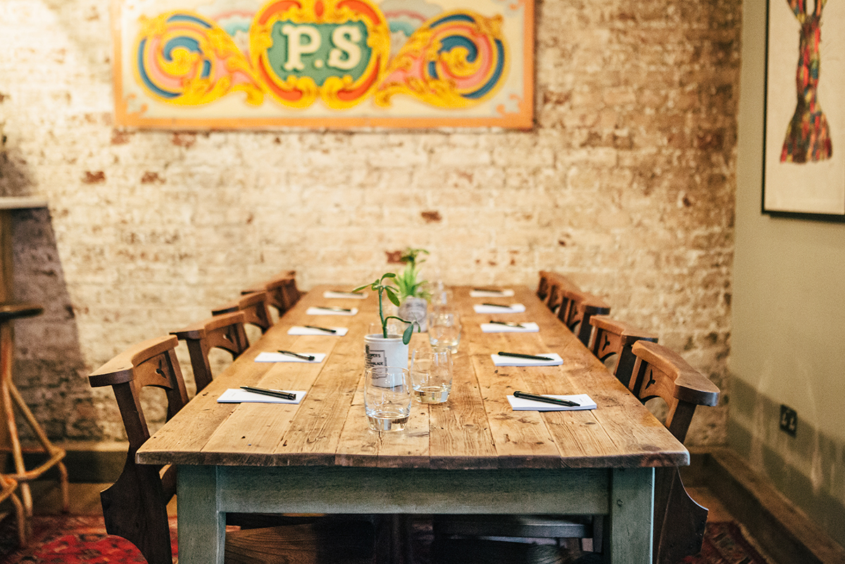 Rustic meeting space with wooden table in Artist Residence London for intimate gatherings.